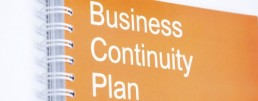 A note pad which has the words 'Business Continuity Plan' on the front of it