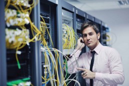 A man sorting out cables in a server room